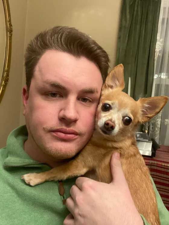 Taco, a small tan chihuahua, resting on Edward's shoulder and leaning against his head